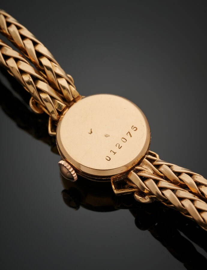 BRACELET MONTRE ronde de dame en or jaune (750‰). Attaches « cornes d'abondance…