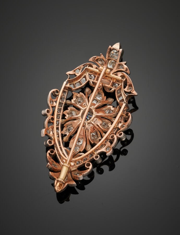 BROCHE en or jaune et or gris (750%) ajourés, à motif de fleur, et volutes, ser…