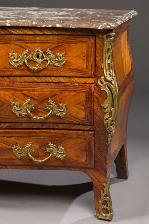 Commode galbée en placage de marqueterie ouvrant par quatre - tiroirs sur trois…