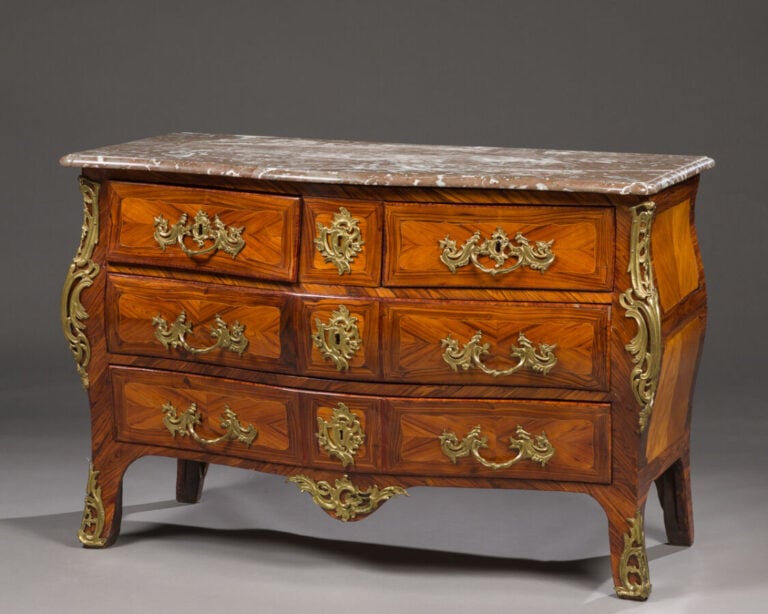 Commode galbée en placage de marqueterie ouvrant par quatre - tiroirs sur trois…