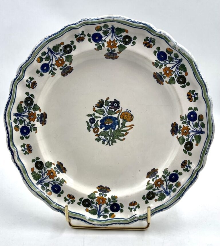 MOUSTIERS - Deux assiettes à bord contourné, l'une à décor polychrome de - roch…