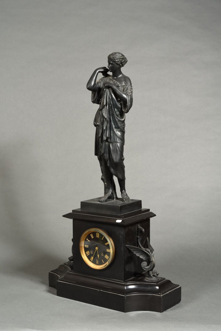 Pendule de cheminée en marbre noir formant socle surmontée d'un groupe en bronz…