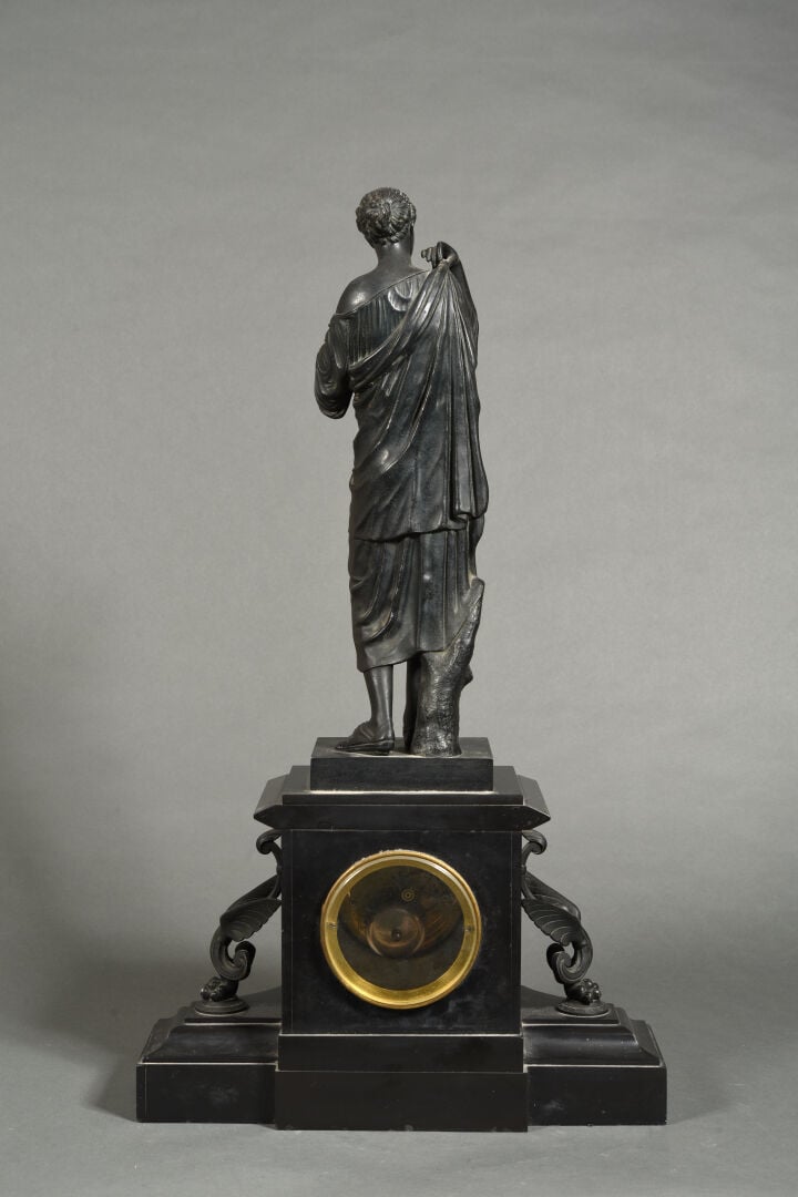 Pendule de cheminée en marbre noir formant socle surmontée d'un groupe en bronz…