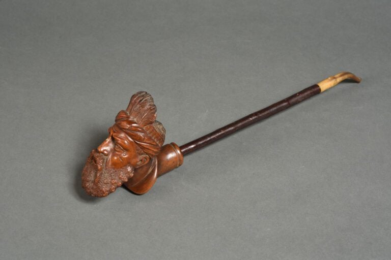 Pipe en noyer sculpté d'une tête de personnage orné d'une coiffe à plumes - Art…