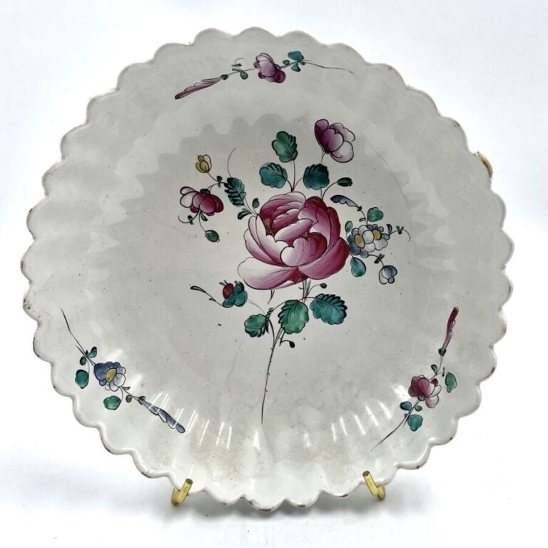 SCEAUX - Une assiette à décor polychrome de fleurs et peignés pourpres et - une…