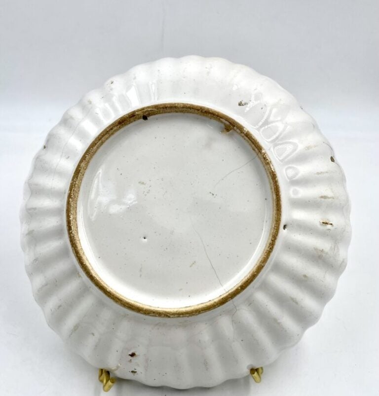 SCEAUX - Une assiette à décor polychrome de fleurs et peignés pourpres et - une…