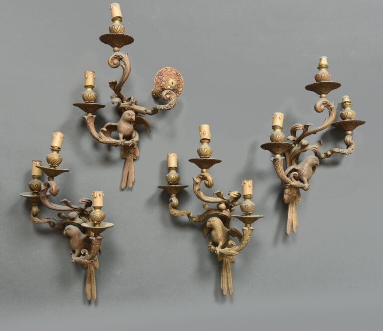 Suite de quatre appliques en bronze doré ciselé à trois bras de lumière ornés d…