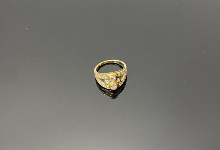 Bague en or jaune (750) à monture ajourée centrée de deux diamants taille brill…