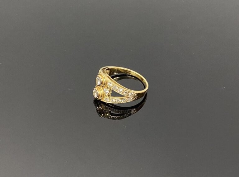 Bague en or jaune (750) à monture ajourée centrée de deux diamants taille brill…