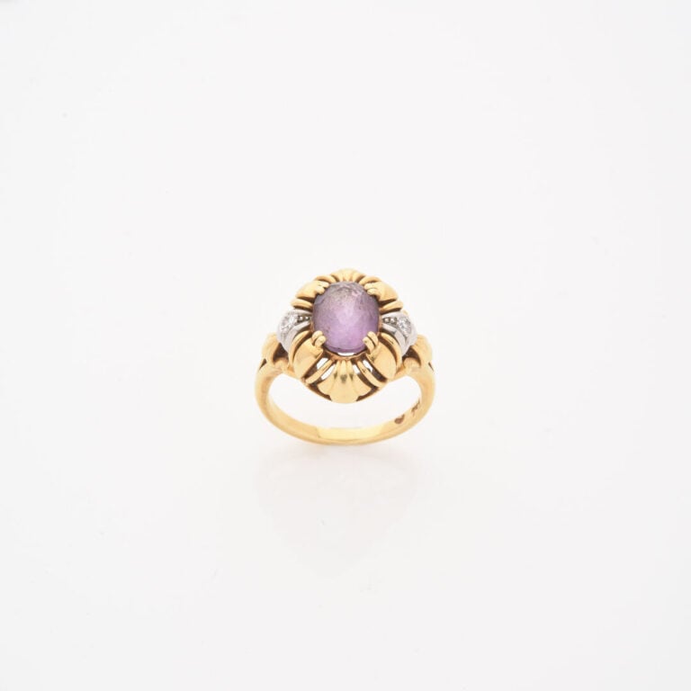 *Bague en or jaune (750) ornée d'une améthyste de taille ovale facettée en sert…