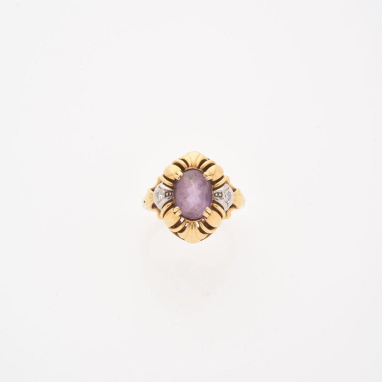 *Bague en or jaune (750) ornée d'une améthyste de taille ovale facettée en sert…
