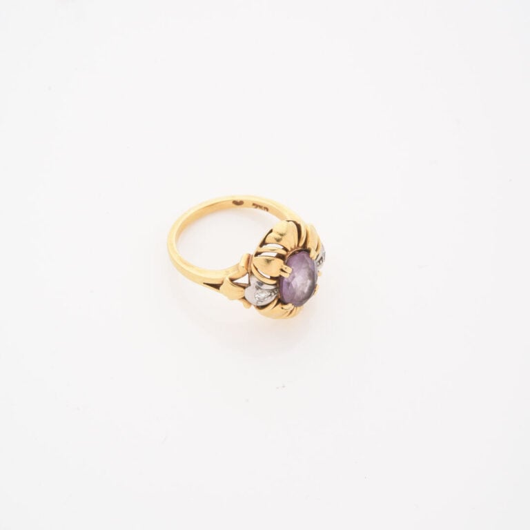 *Bague en or jaune (750) ornée d'une améthyste de taille ovale facettée en sert…