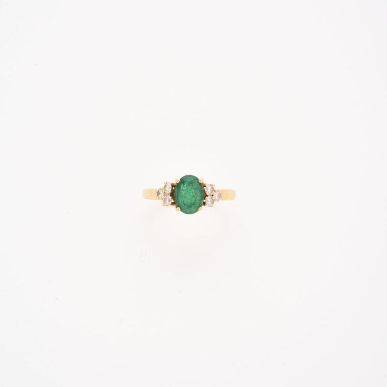 Bague en or jaune (750) ornée d'une émeraude de taille ovale facettée épaulée d…