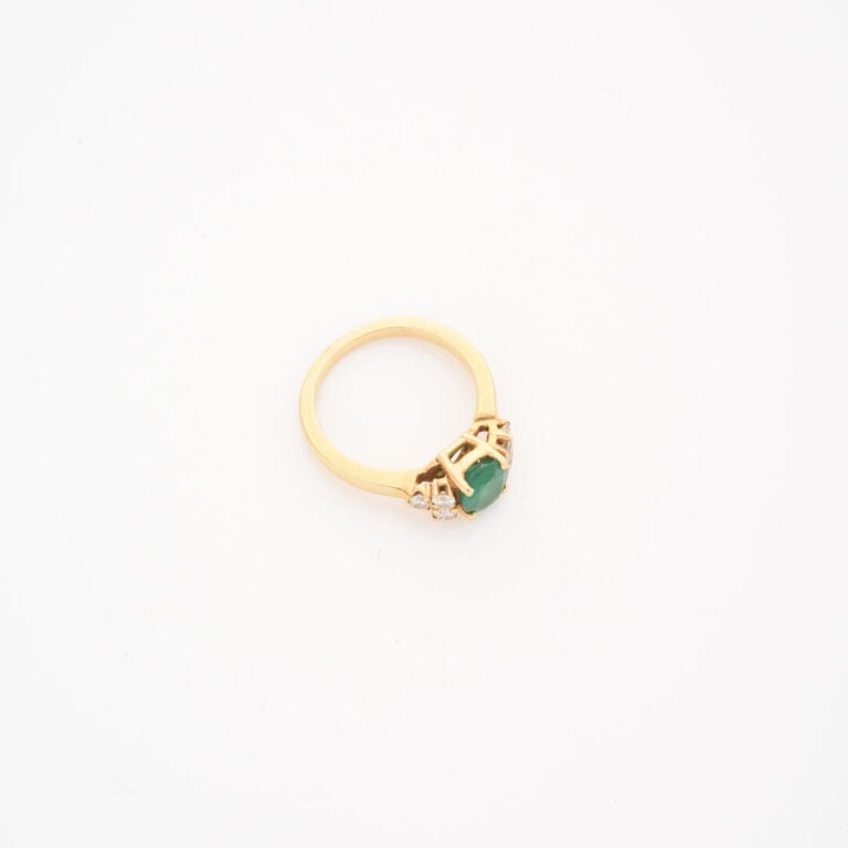 Bague en or jaune (750) ornée d'une émeraude de taille ovale facettée épaulée d…