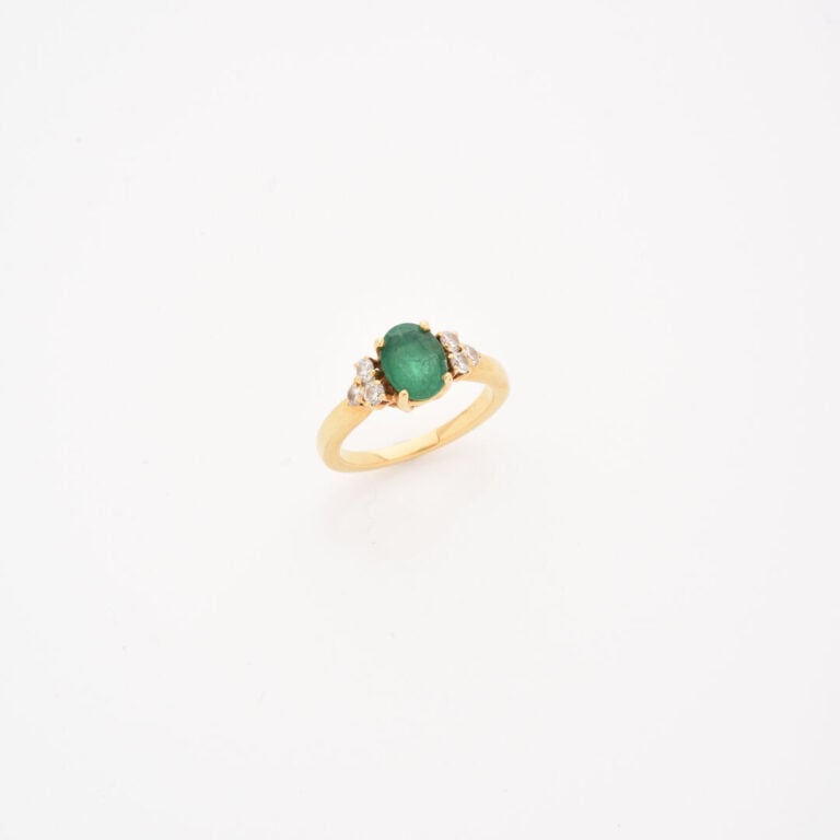 Bague en or jaune (750) ornée d'une émeraude de taille ovale facettée épaulée d…
