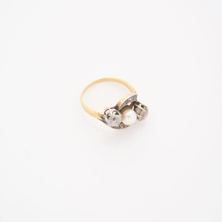 *Bague en ors jaune et gris (750) centrée d'une perle de culture épaulée de deu…