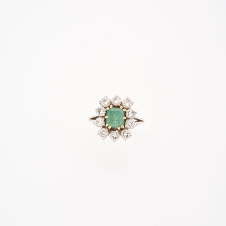 Bague marguerite en or gris (750) ornée d'une émeraude rectangulaire taillée à…