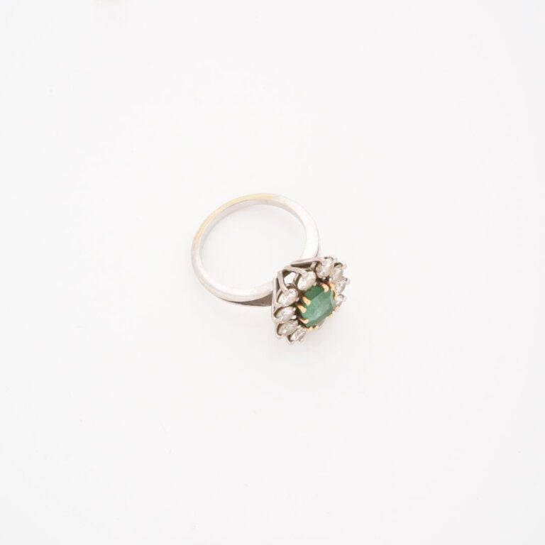 Bague marguerite en or gris (750) ornée d'une émeraude rectangulaire taillée à…