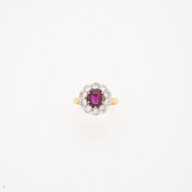 Bague marguerite en ors (750) jaune et gris centrée d'un rubis de taille ovale…