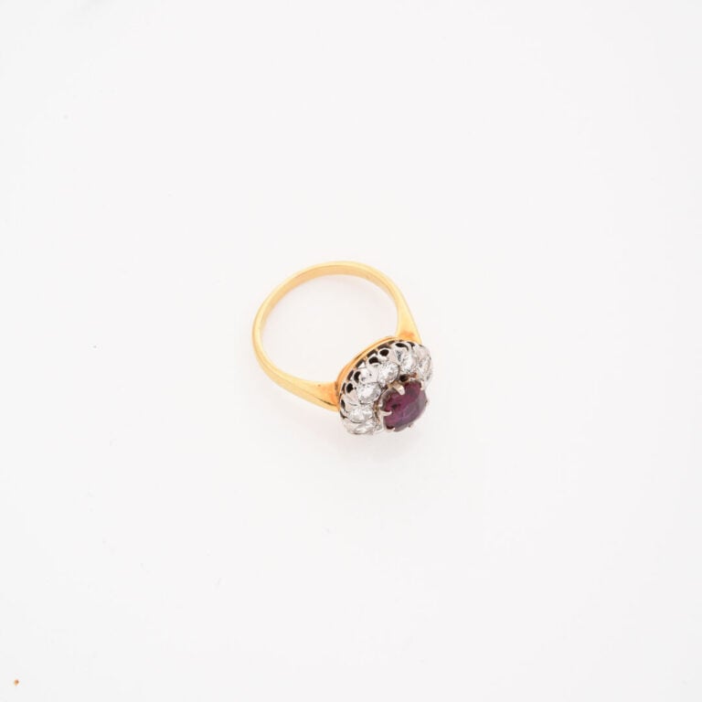Bague marguerite en ors (750) jaune et gris centrée d'un rubis de taille ovale…
