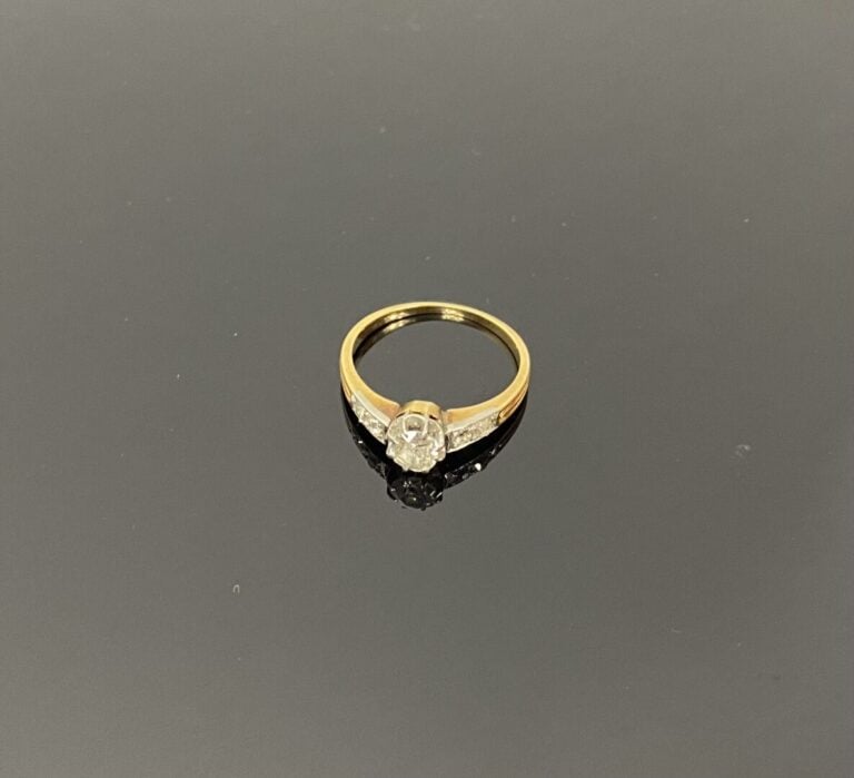 Bague solitaire en ors jaune et gris (750) ornée d'un diamant demi-taille en se…