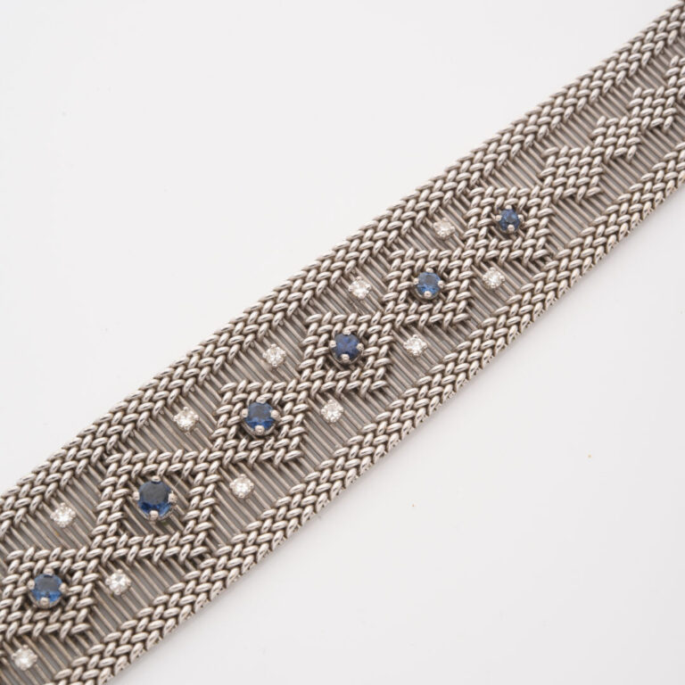 Bracelet ruban en or gris (750) à maille souple ajourée et tressée centrée d'un…