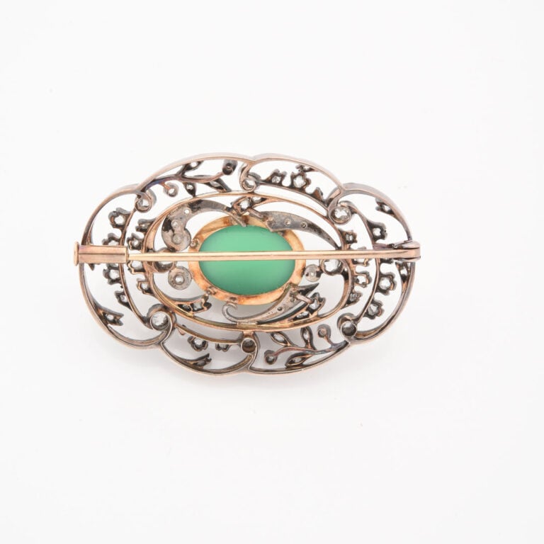 *Broche en or jaune (750) et argent (800) à motif ajouré centré d'un cabochon d…