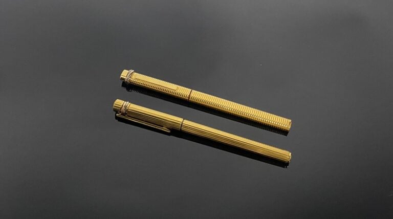CARTIER - Deux stylos "Trinity" en métal doré, l'un godronné, l'autre rainuré -…