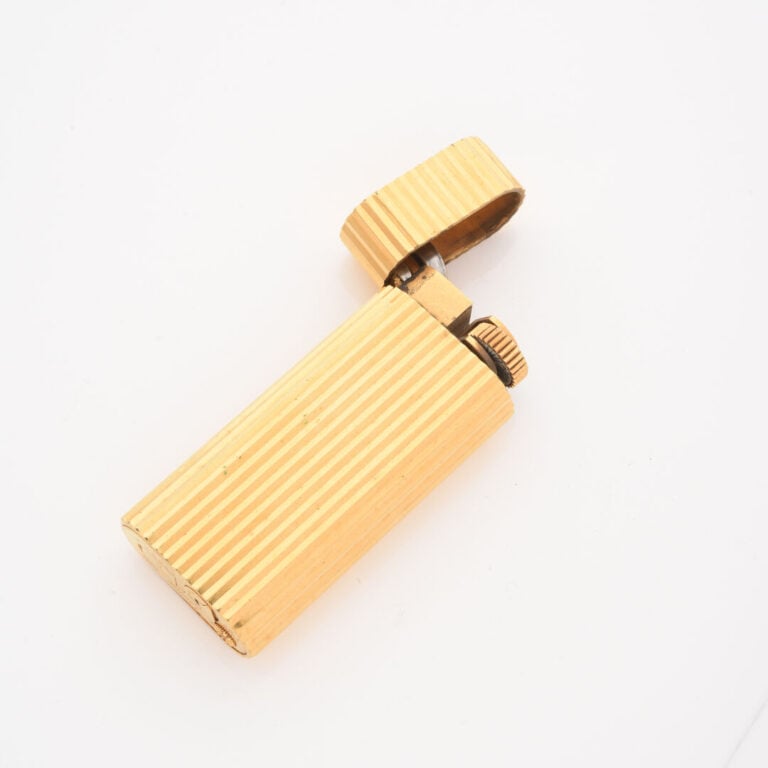 CARTIER Paris - Briquet en métal doré à décor rainuré - Signé et numéroté 89609…