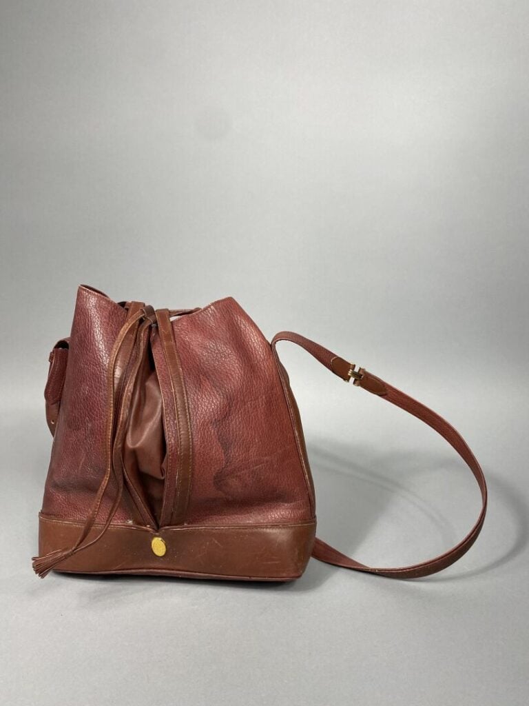 CARTIER - Sac bourse en cuir bordeaux « Must de Cartier », intérieur en tissu b…