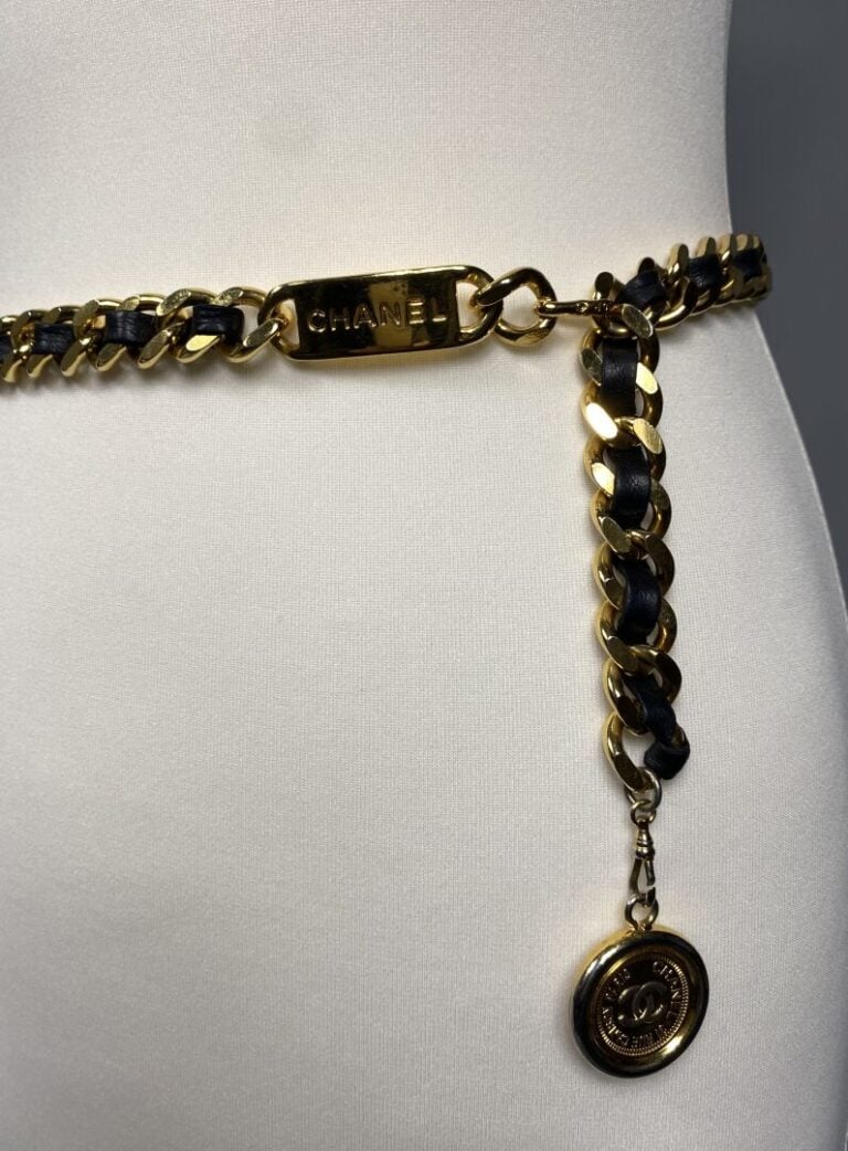 CHANEL - Année 1995 - Ceinture chaîne dorée entrelacée de cuir noir, plaque dor…