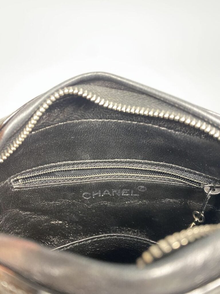 CHANEL - Années 1996/97 - Petit sac en cuir matelassé noir verni, attributs arg…