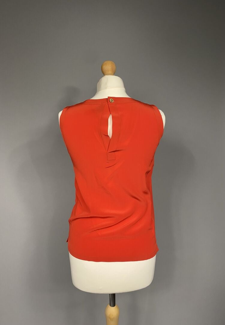 CHANEL - Blouse sans manche à encolure ronde en soie rouge, fermeture par un bo…