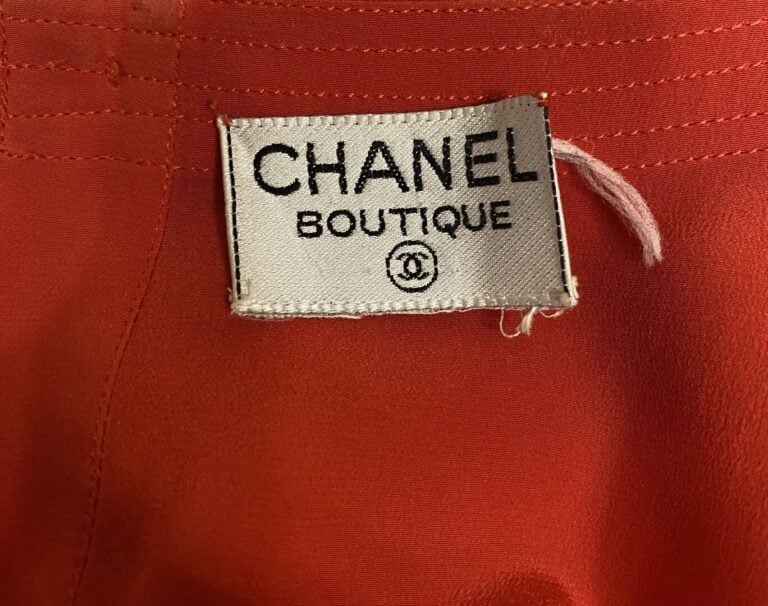 CHANEL - Blouse sans manche à encolure ronde en soie rouge, fermeture par un bo…