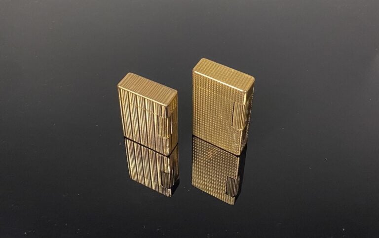 DUPONT - Lot de deux briquets en métal doré à décor rainuré ou motif de pointes…