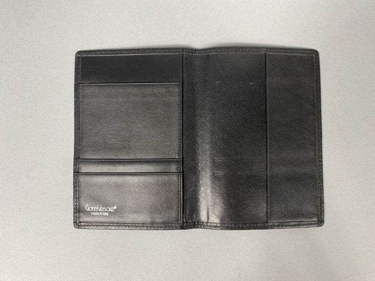 Gianni VERSACE - Portefeuille en cuir noir, trois compartiments cartes, signé à…