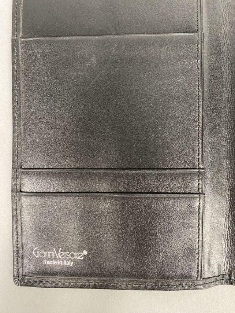 Gianni VERSACE - Portefeuille en cuir noir, trois compartiments cartes, signé à…