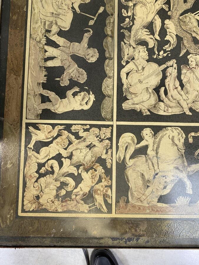 Grande table basse en métal à piétement feuillagé arqué ; le plateau en grisail…