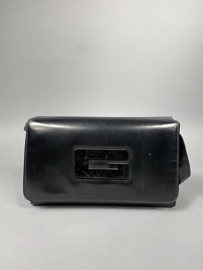 GUCCI - Sac en cuir glacé noir, fermeture à rabat siglé G, porté épaule bandoul…