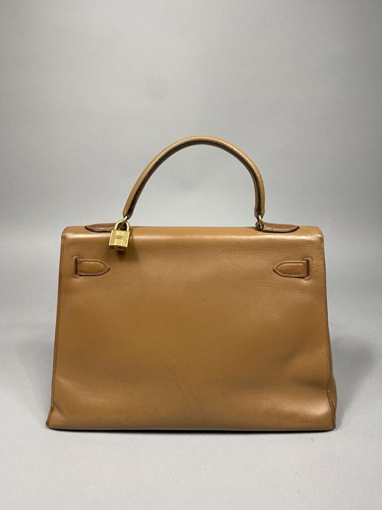 HERMÈS - Année 1974. - Sac « Kelly sellier » 32 cm en cuir beige, attributs dor…