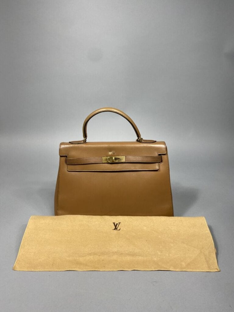 HERMÈS - Année 1974. - Sac « Kelly sellier » 32 cm en cuir beige, attributs dor…