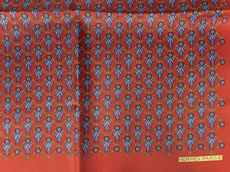 HERMÈS - Ensemble de deux pochettes homme en twill de soie rouge, l'un à décor…