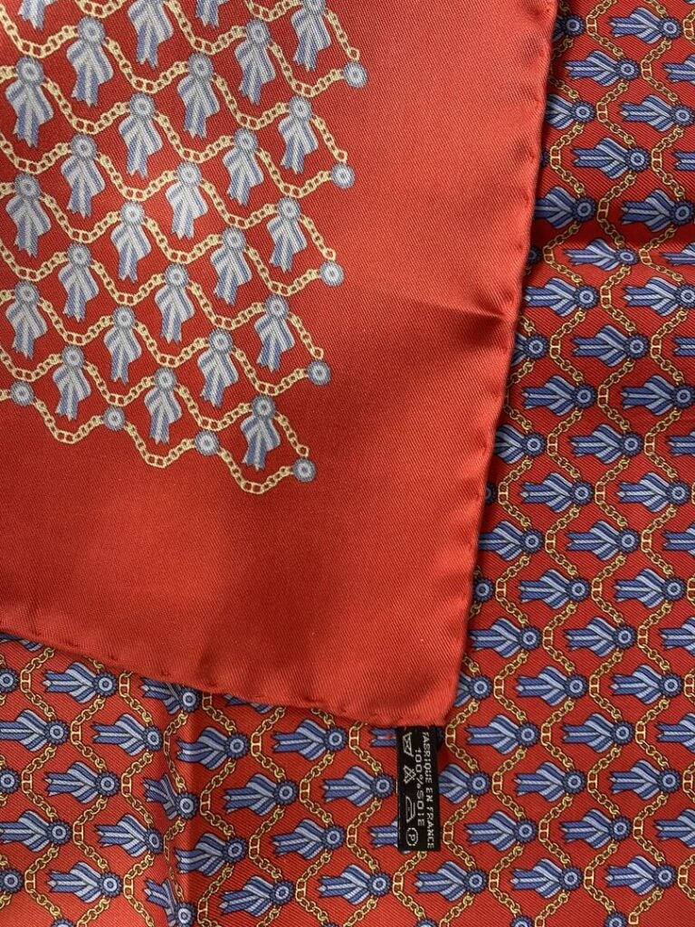 HERMÈS - Ensemble de deux pochettes homme en twill de soie rouge, l'un à décor…