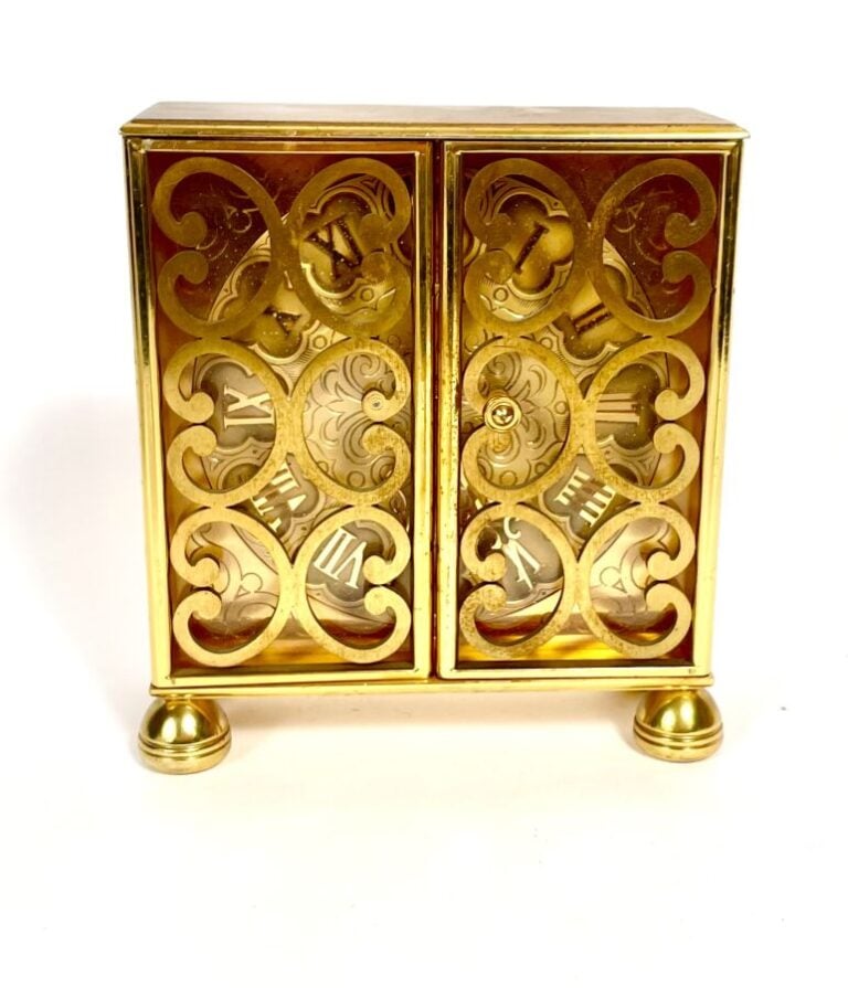 IMHOF. Pendulette en laiton doré ouvrant par deux portes ajourées (manque un bo…