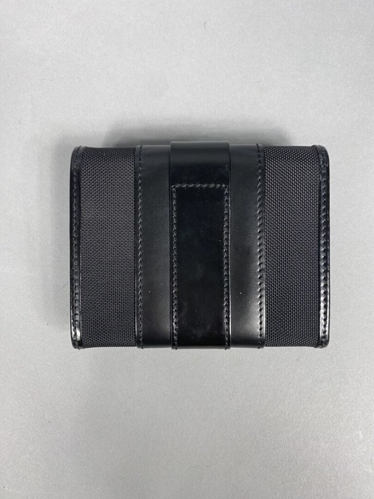 LANCEL - Porte-monnaie en toile et cuir noir découvrant un intérieur à trois co…