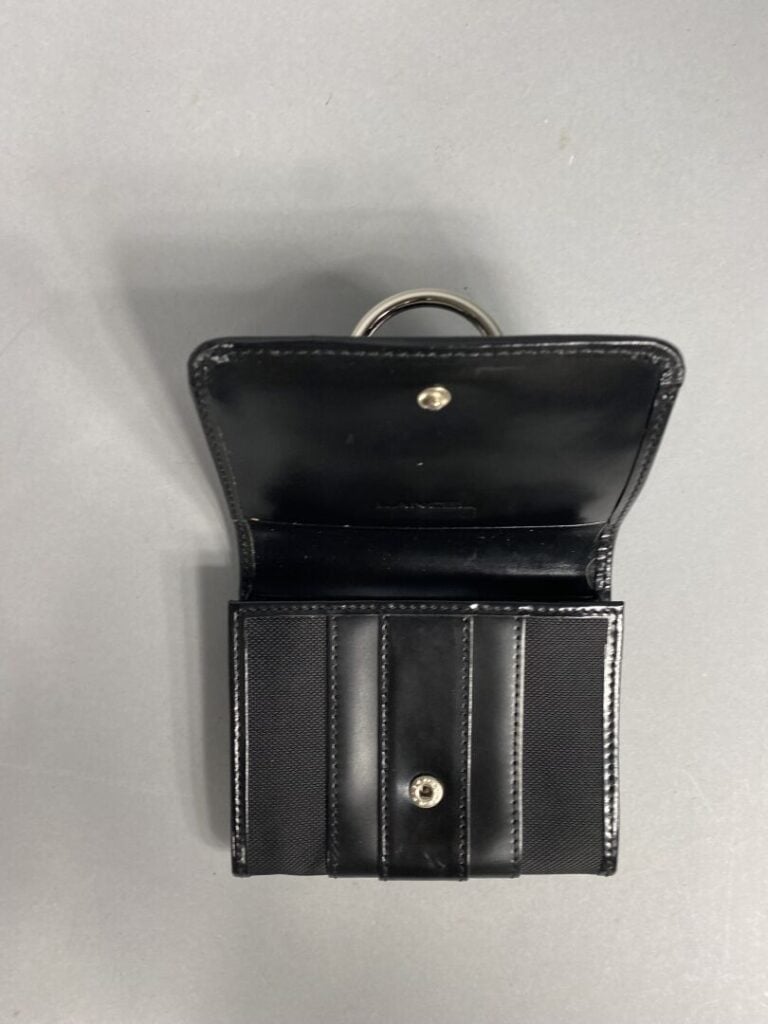 LANCEL - Porte-monnaie en toile et cuir noir découvrant un intérieur à trois co…