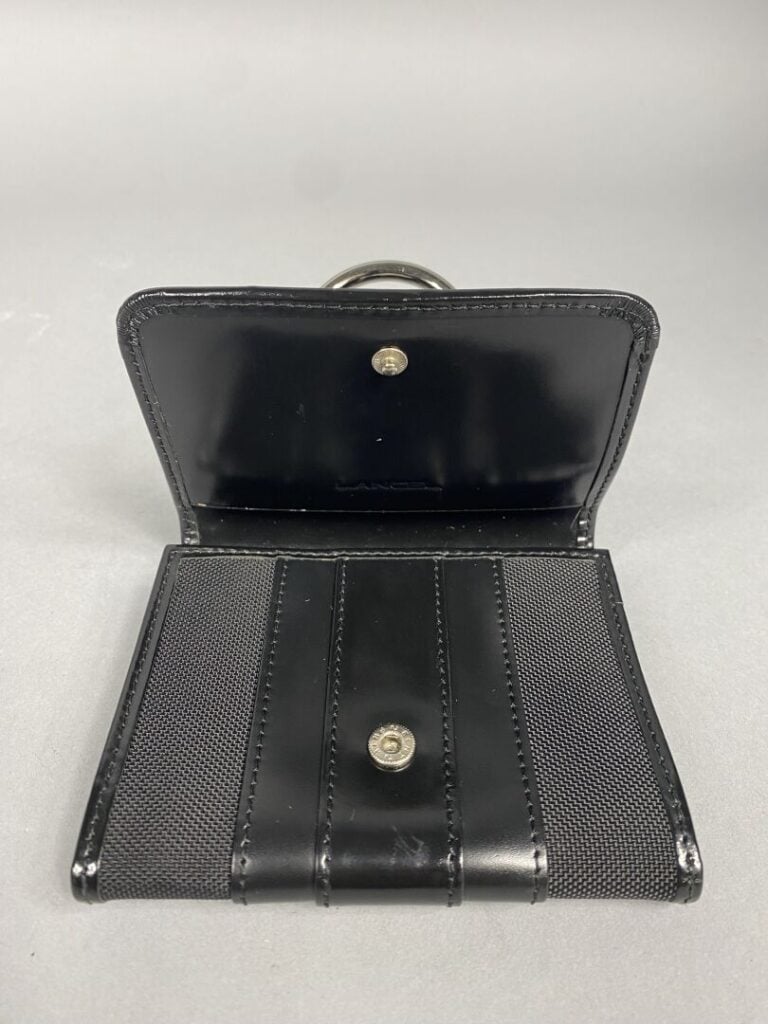LANCEL - Porte-monnaie en toile et cuir noir découvrant un intérieur à trois co…