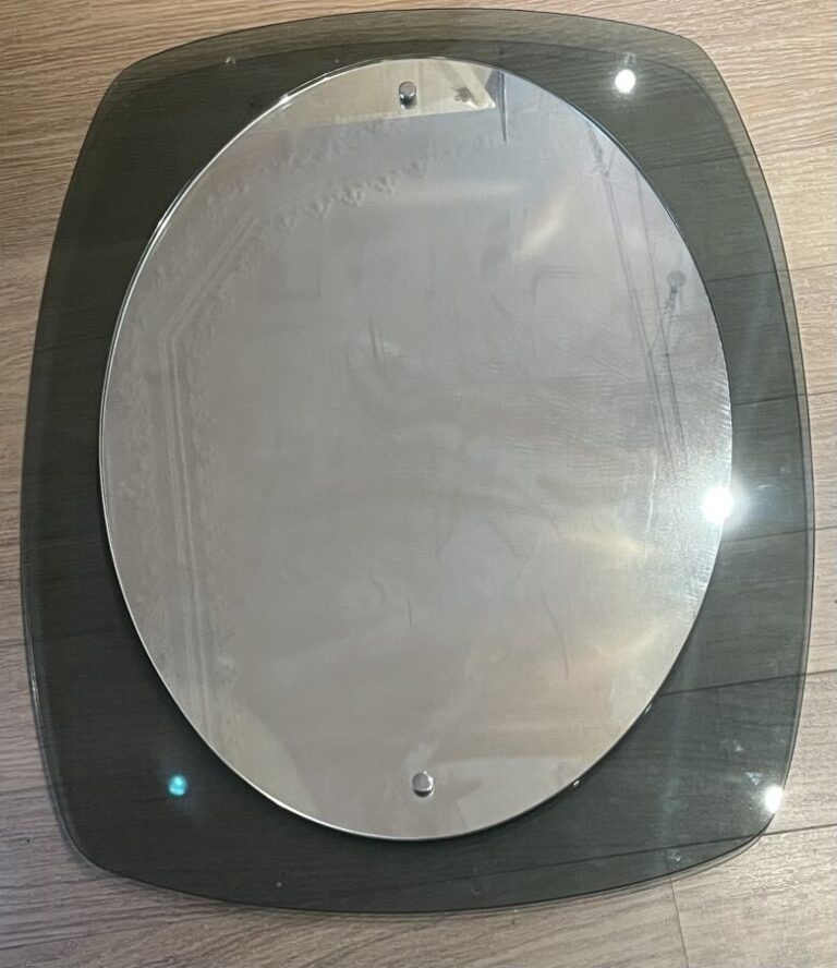 Miroir ovale sur un entourage de plexi gris fumé - 59 x 34 cm