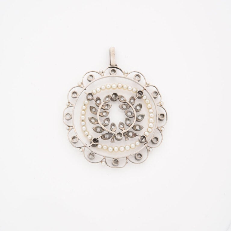 *Pendentif circulaire en or gris (375) à décor ajouré de guirlandes de laurier…