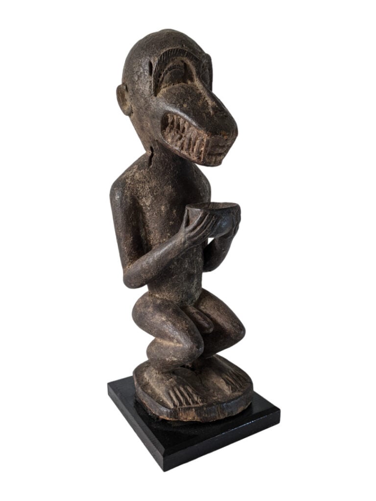 Statue simiesque Baoulé (Côte d'Ivoire) en bois dur, érodée à sa base et avec u…